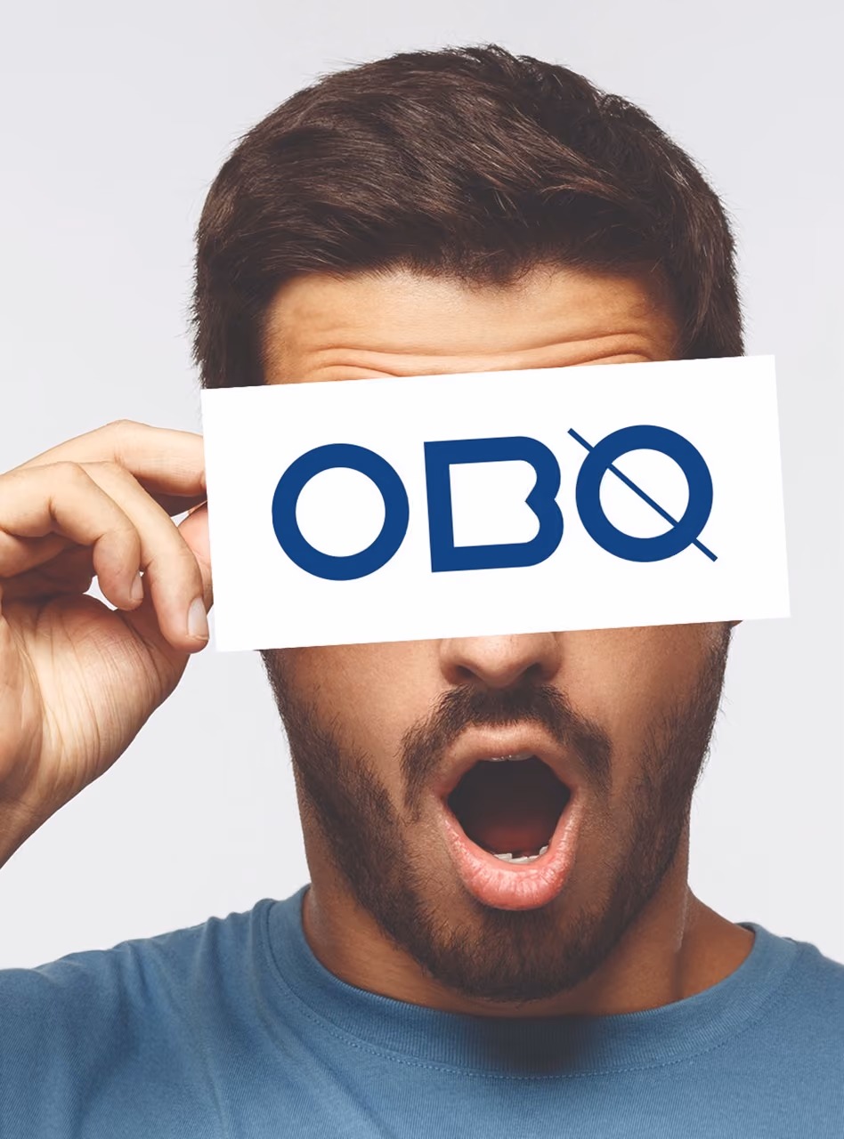 Homme surpris tenant une étiquette « OBO » devant ses yeux