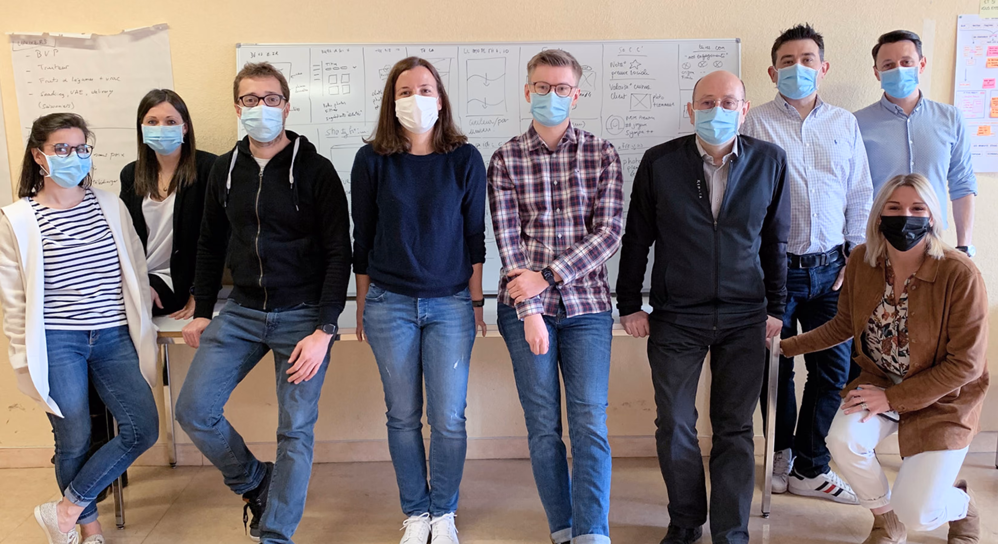 Équipe de Gault & Frémont portant des masques, posant devant un tableau blanc
