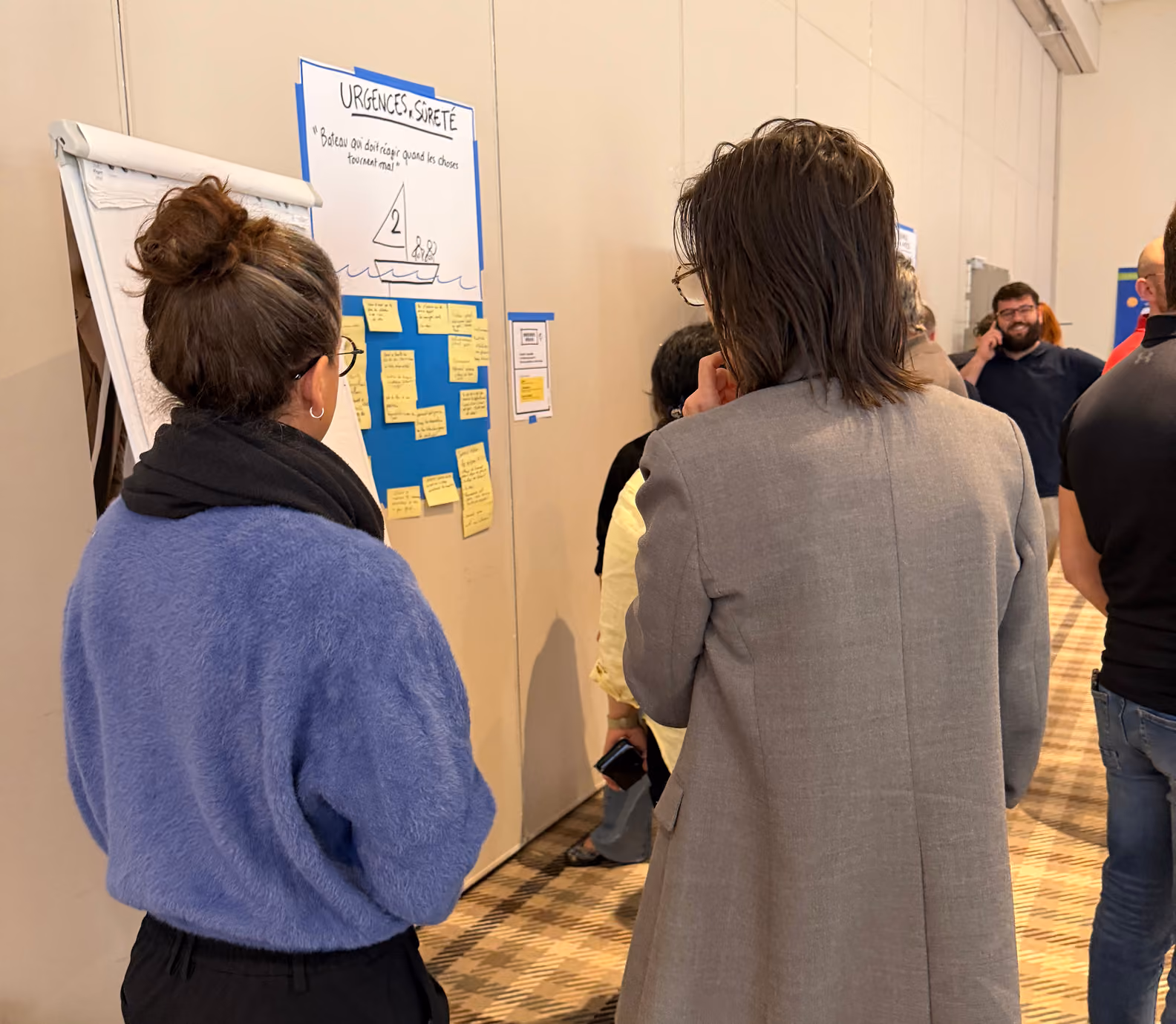 Animatrice et participants devant un panneau « Urgence et sûreté » couvert de post-it