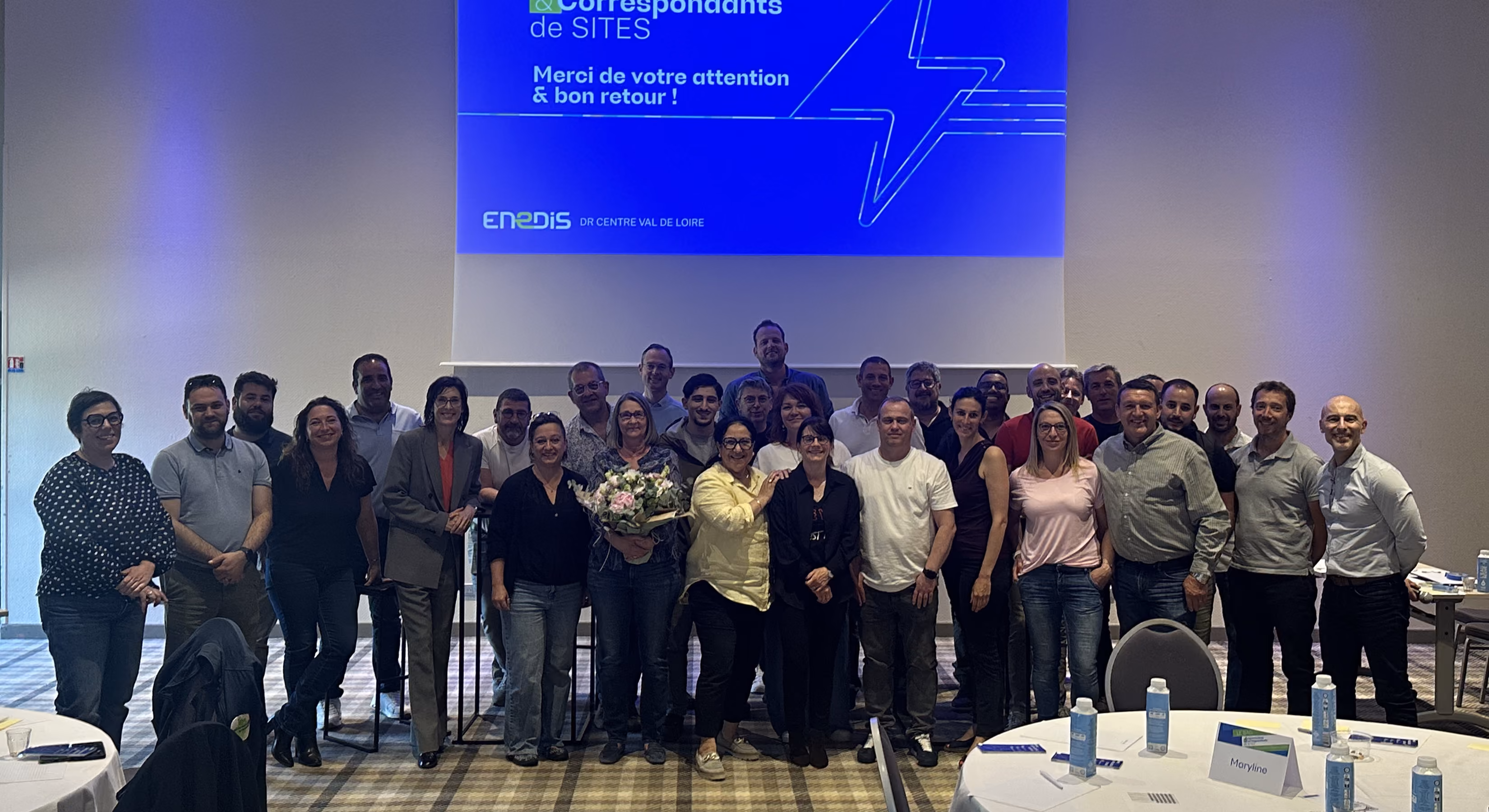 Photo de groupe des participants de l'atelier Enedis devant un écran de présentation