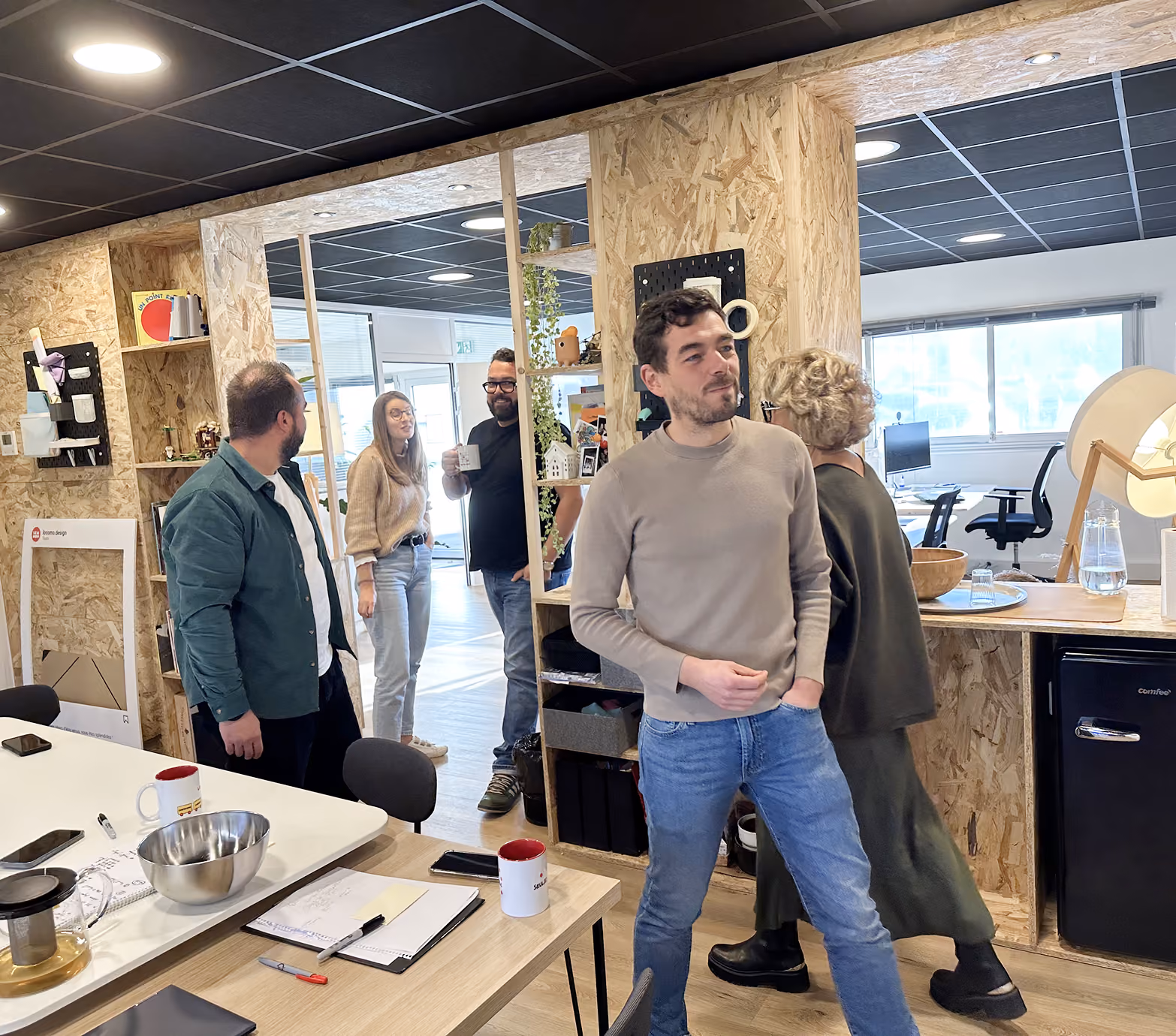 Participants d'un atelier échangeant debout dans les locaux de l'agence