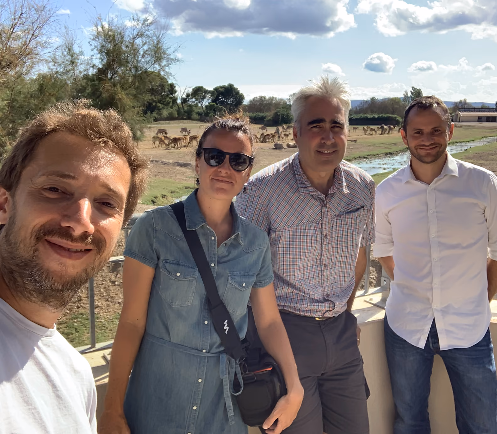 Quatre personnes posant en selfie sur une terrasse face à la réserve