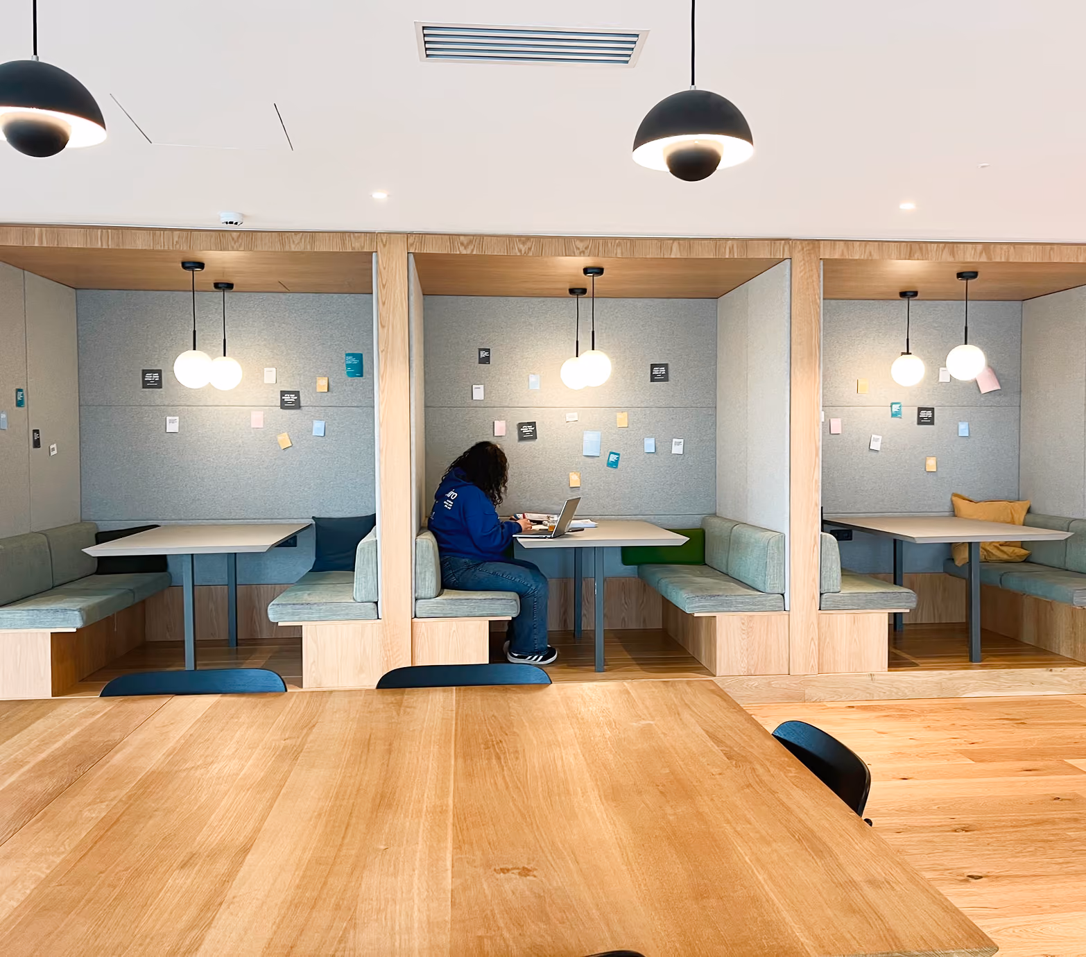 Espace de coworking avec alcôves et grande table en bois