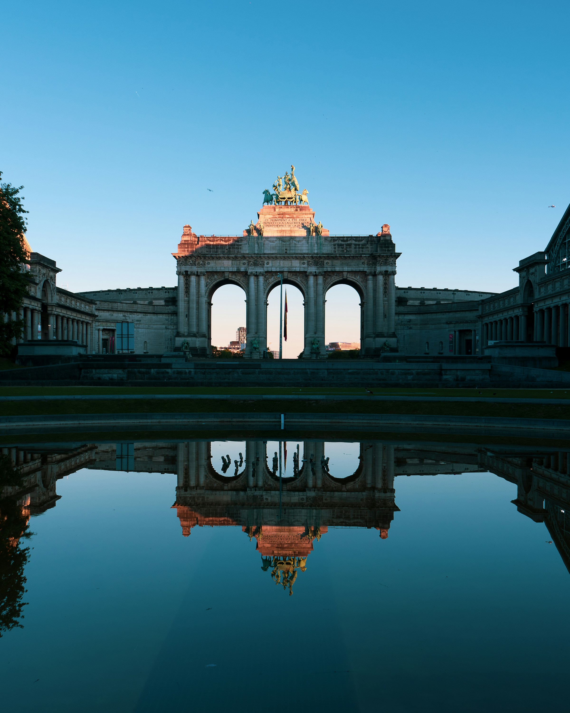 Parc du Cinquantenaire in the European Quarter of Brussels reflected in its basin at sunrise