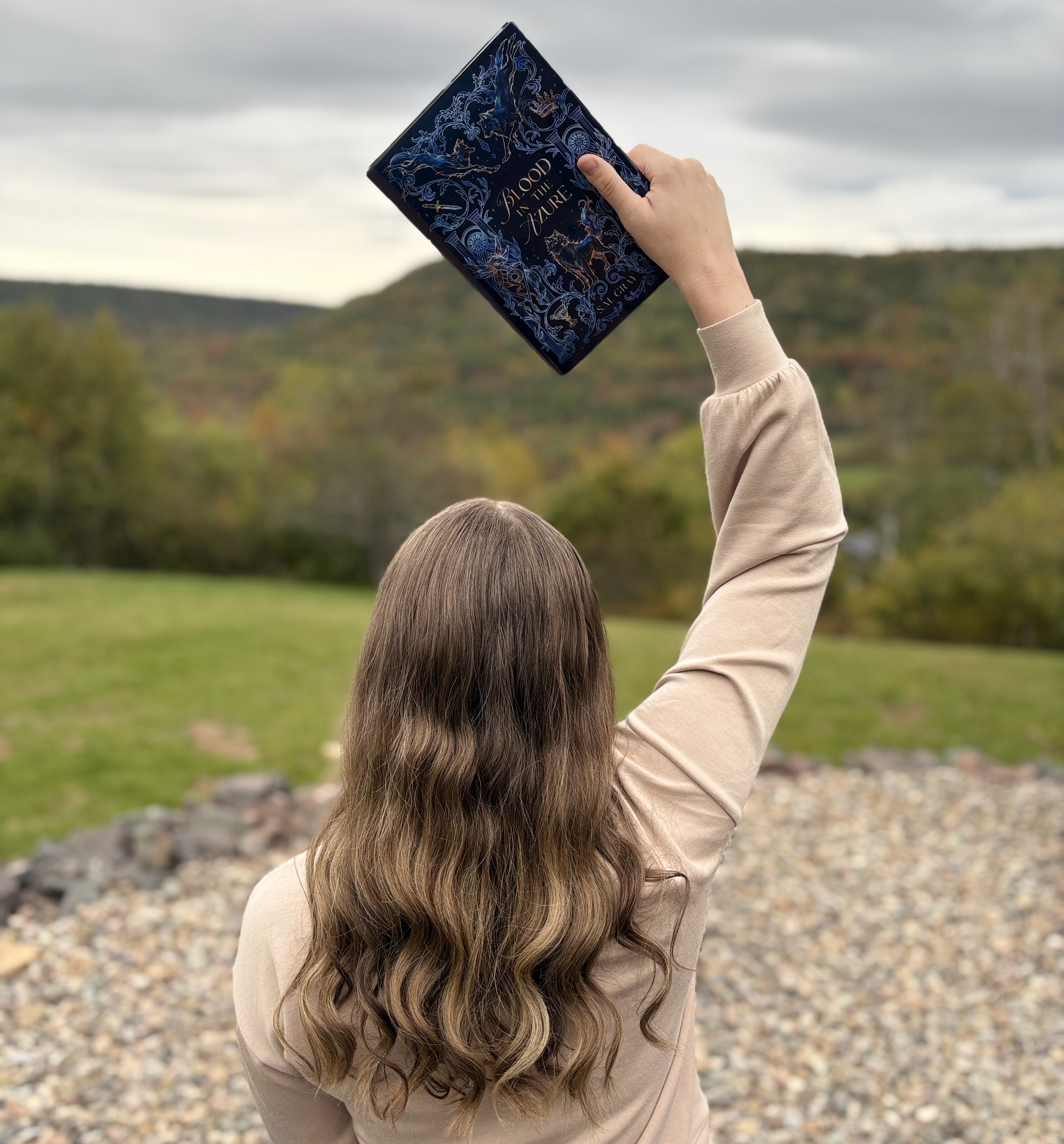 Author SM Gray holds up a copy of Blood in the Azure