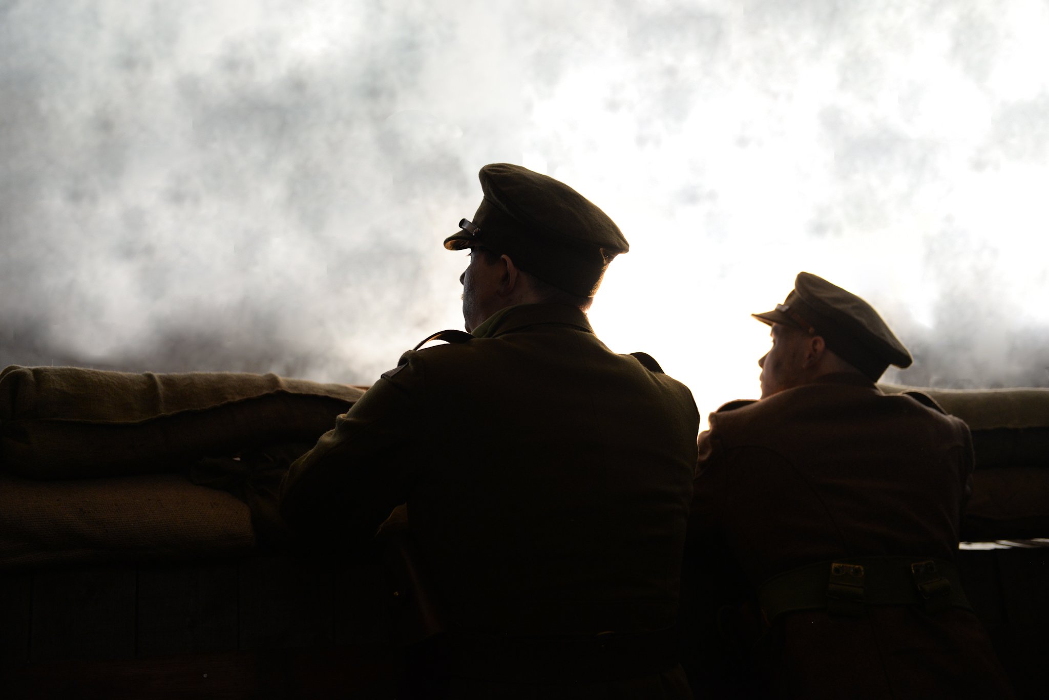 Soldiers silhouetted against a grey sky