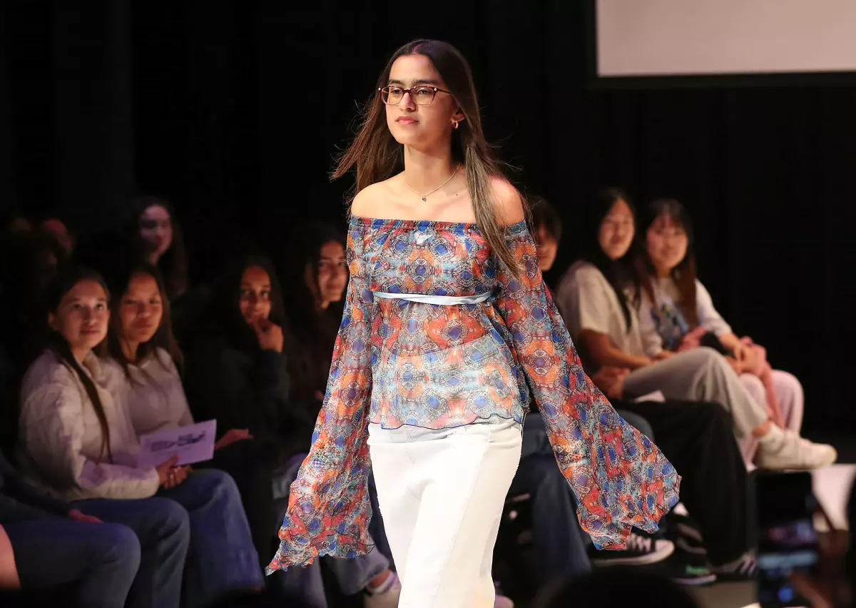 A model walks down a catwalk dressed in upcycled clothes