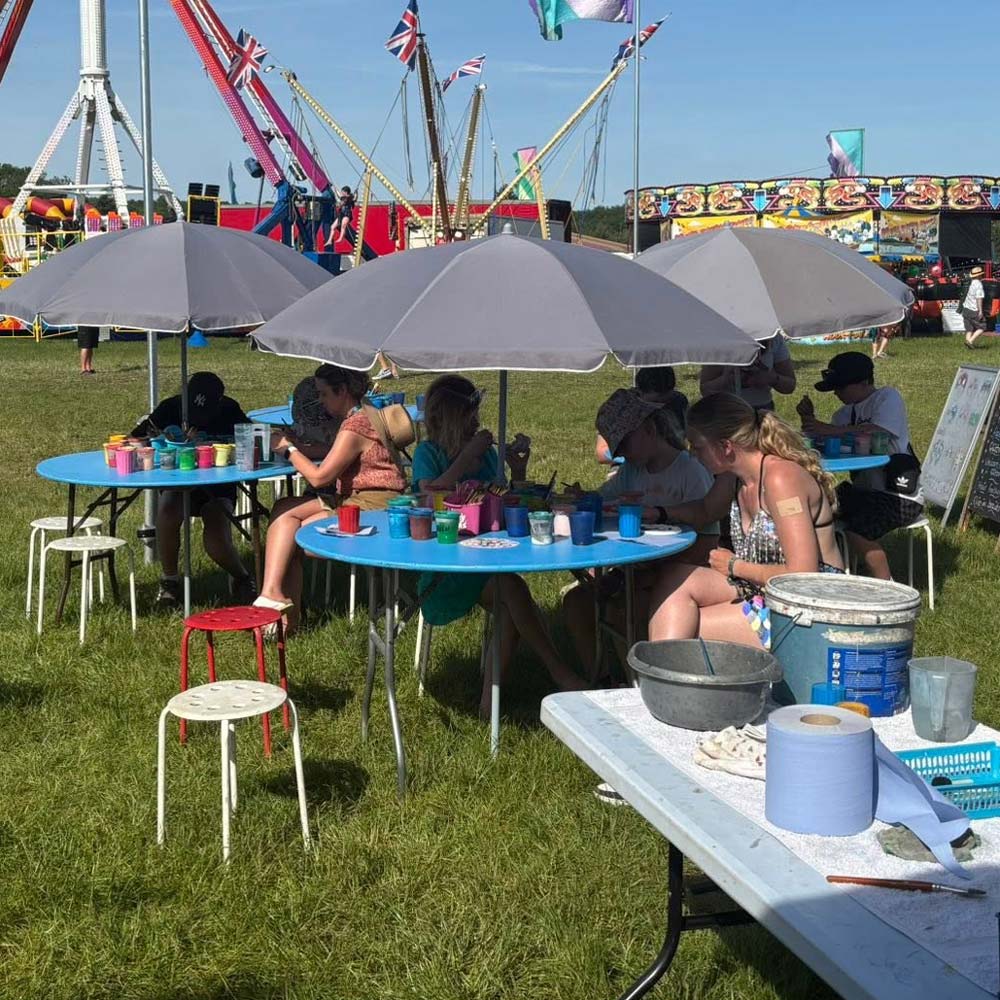 Children and parents painting ceramics at a country fair