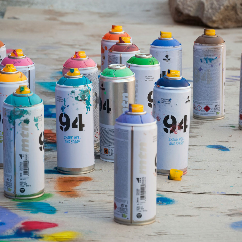 A variety of used spray cans sitting on the floor