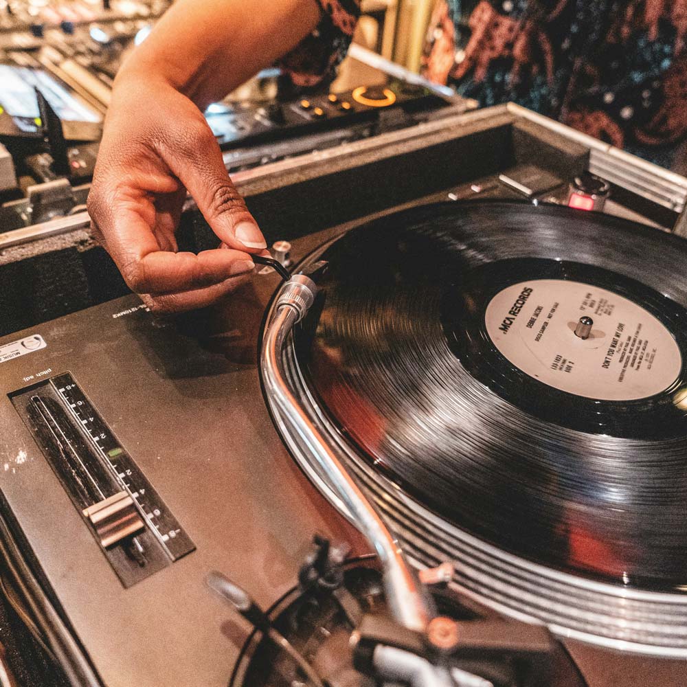 A DJ plays vinyl on some record decks