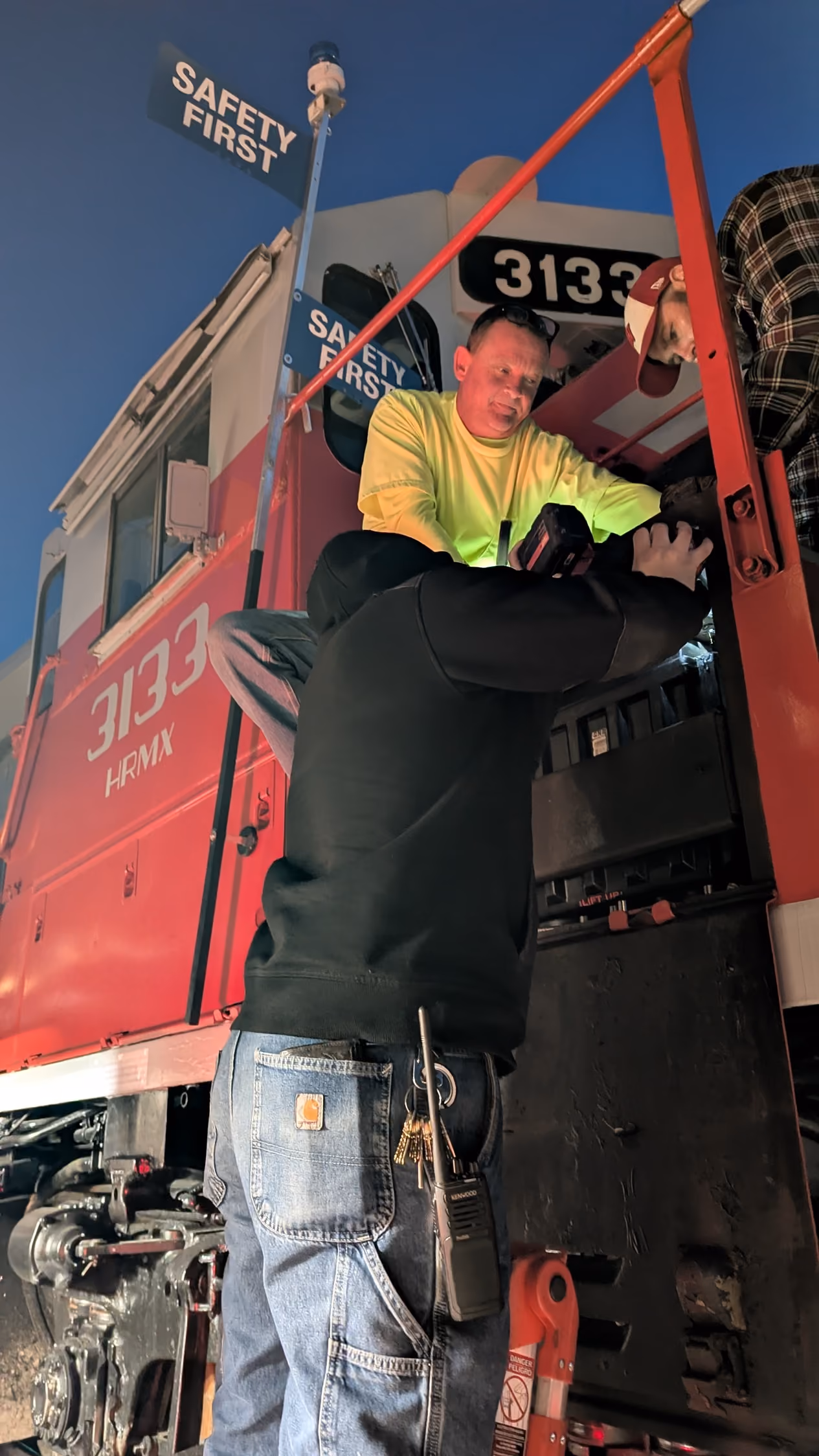 Worker in safety gear standing on top of a rail car