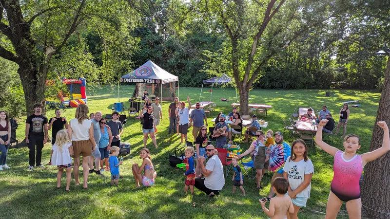 IBEW 453 members and families gathered at an outdoor picnic with a bounce house and tent