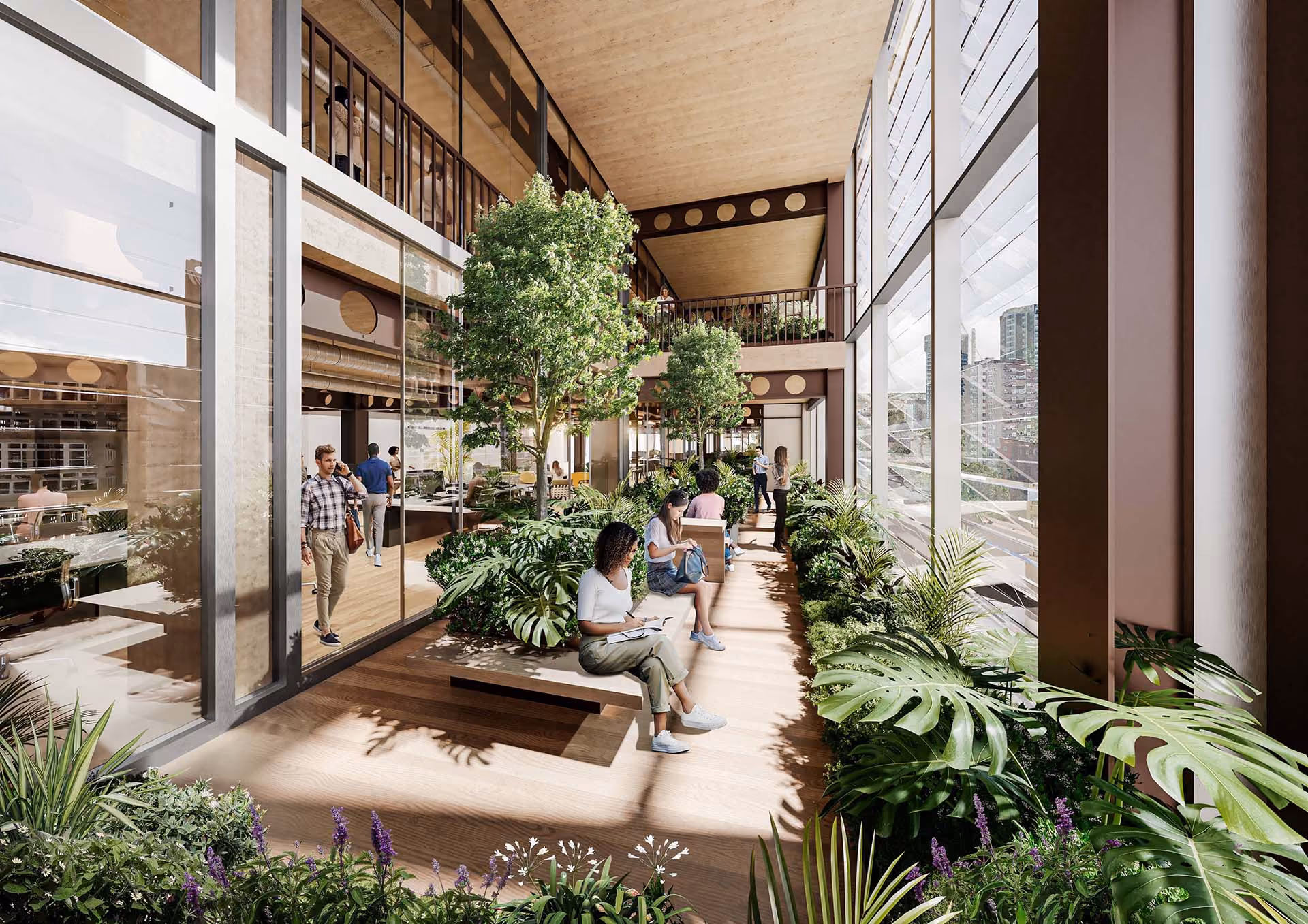 Indoor atrium with large windows, plants, and people sitting and walking on wooden benches.