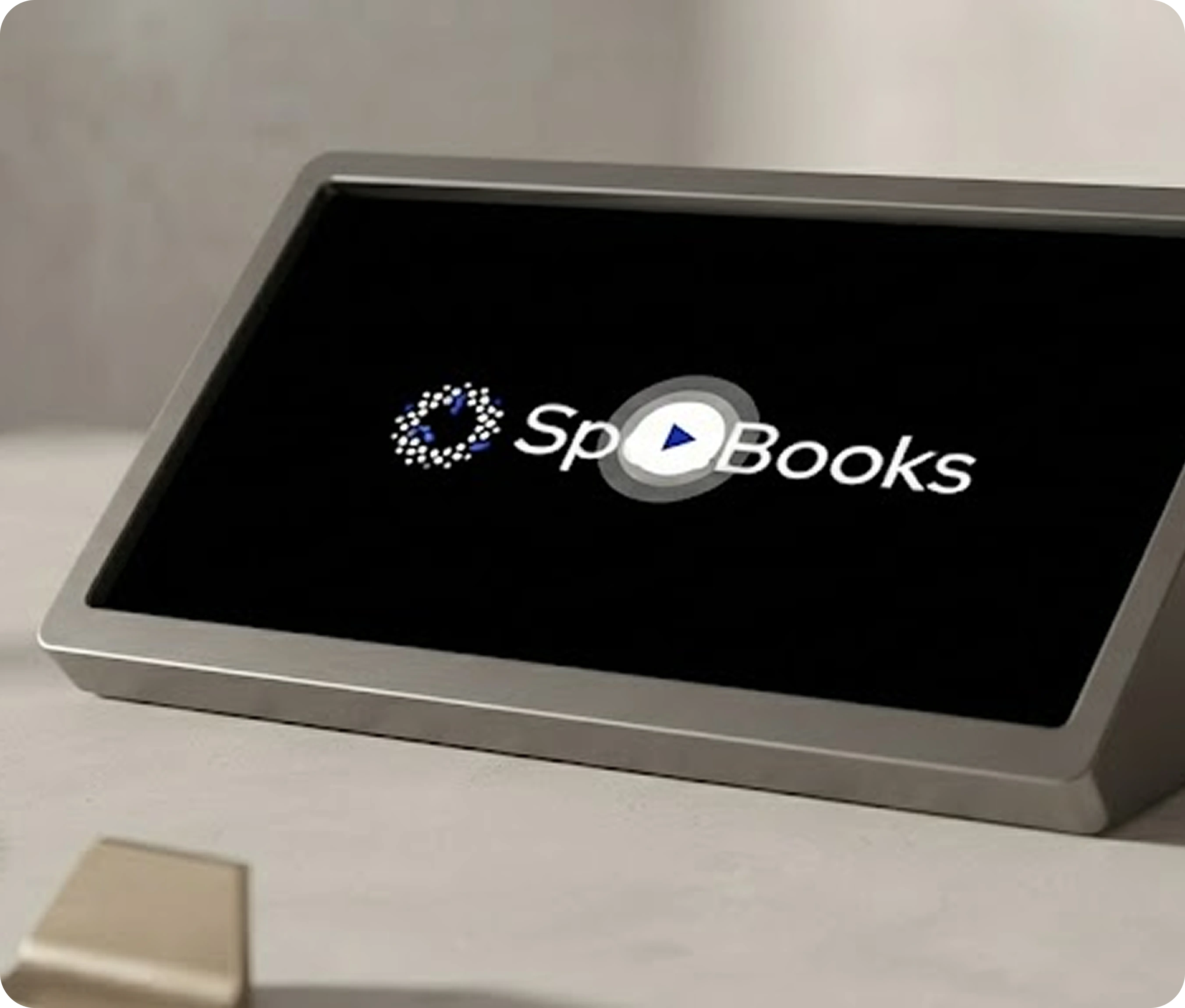 Digital device on a table displaying the logo Sp Books with a play button in the middle.