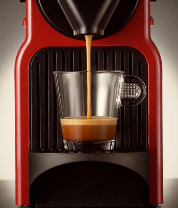Coffee maker in red colour making a coffee cup