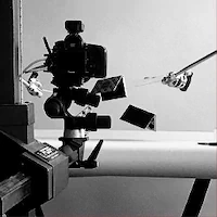 Camera setup capturing objects in motion through the air.