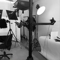 Photography studio setup with lights, camera equipment, and a chair.
