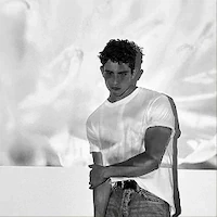 A black and white photo of a male model posing in a white t-shirt and jeans during e-commerce on-model photography shoot at LRP studios.