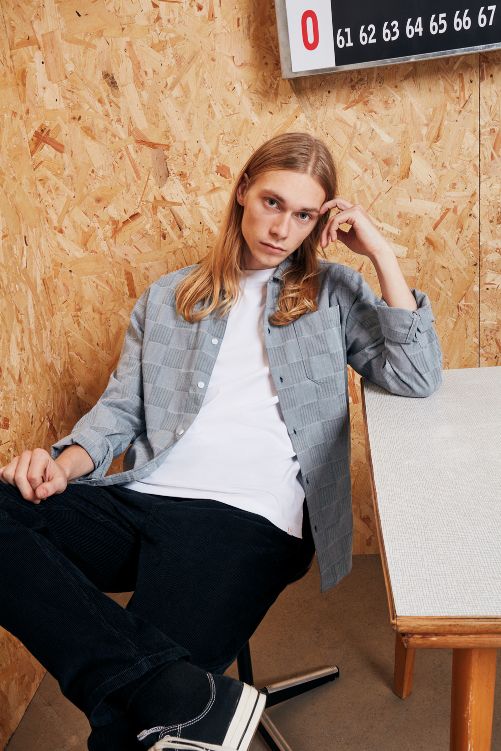 Male model sitting in grey shirt and dark trousers. creative eCommerce fashion shoot for Farah brand