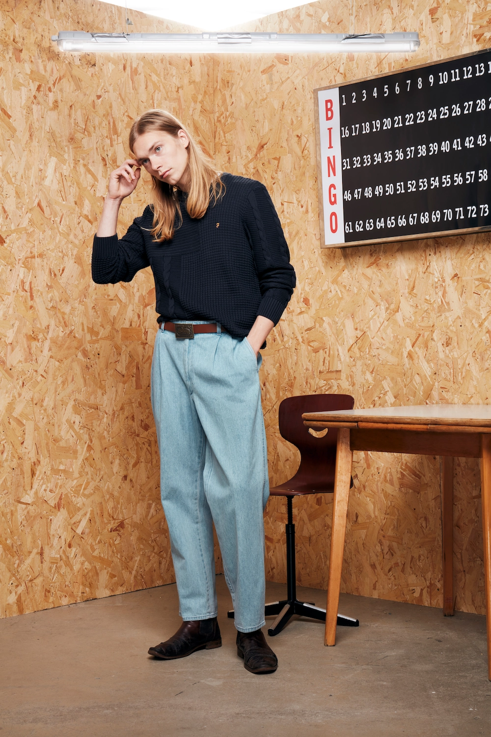 male model with light blue jeans and dark jumper in a creative setting for Farah menswear eCommerce shoot