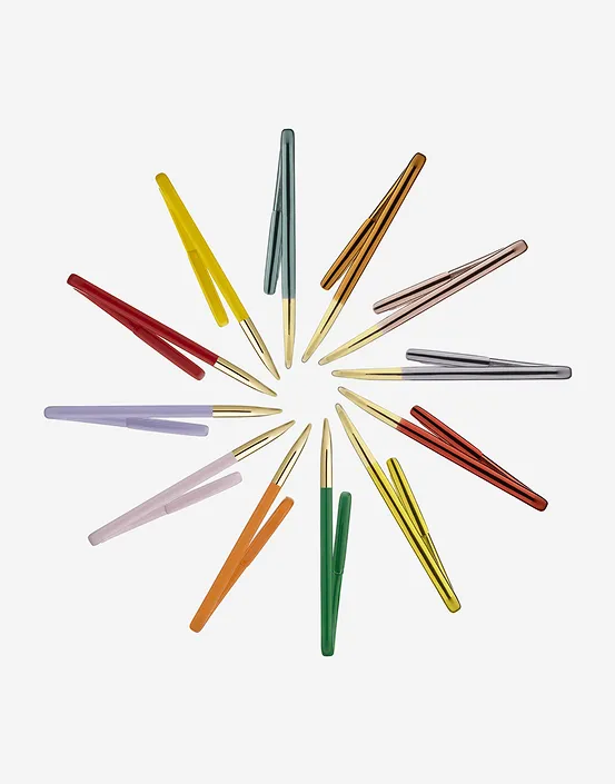Circle of colorful ballpoint pens with gold tips arranged on a white background.