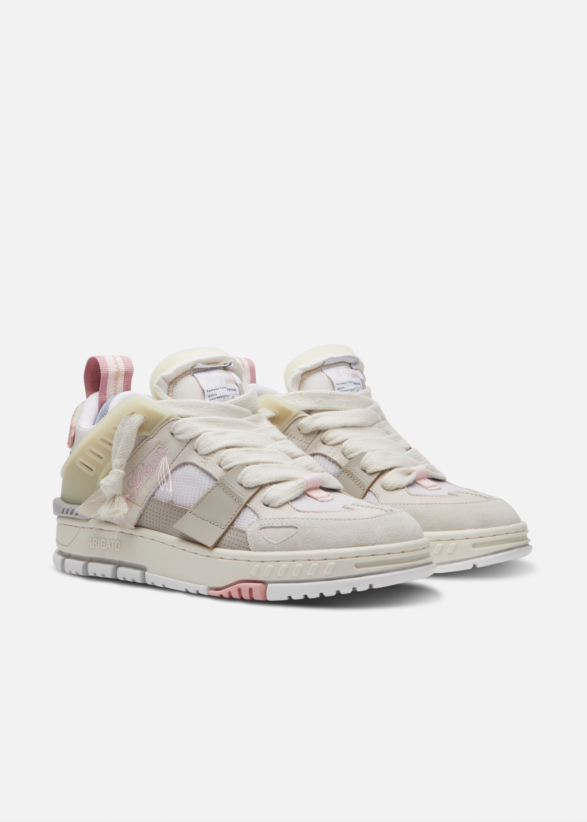 Pair of beige and white Axel Arigato sneakers with pink accents and thick white laces on a white background.