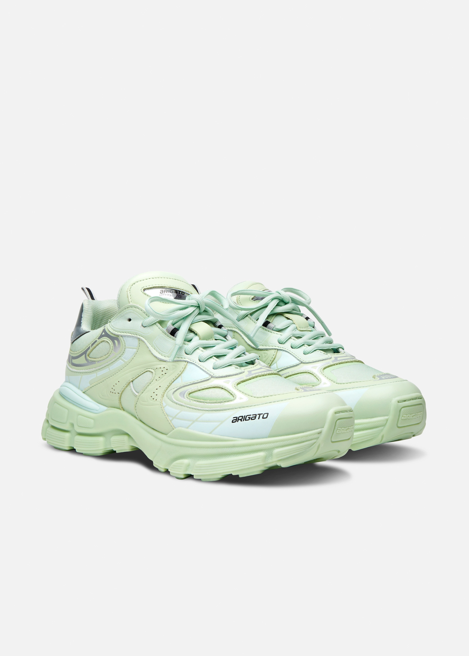 Pair of light green Axel Arigato chunky sneakers with layered detailing and branded soles.