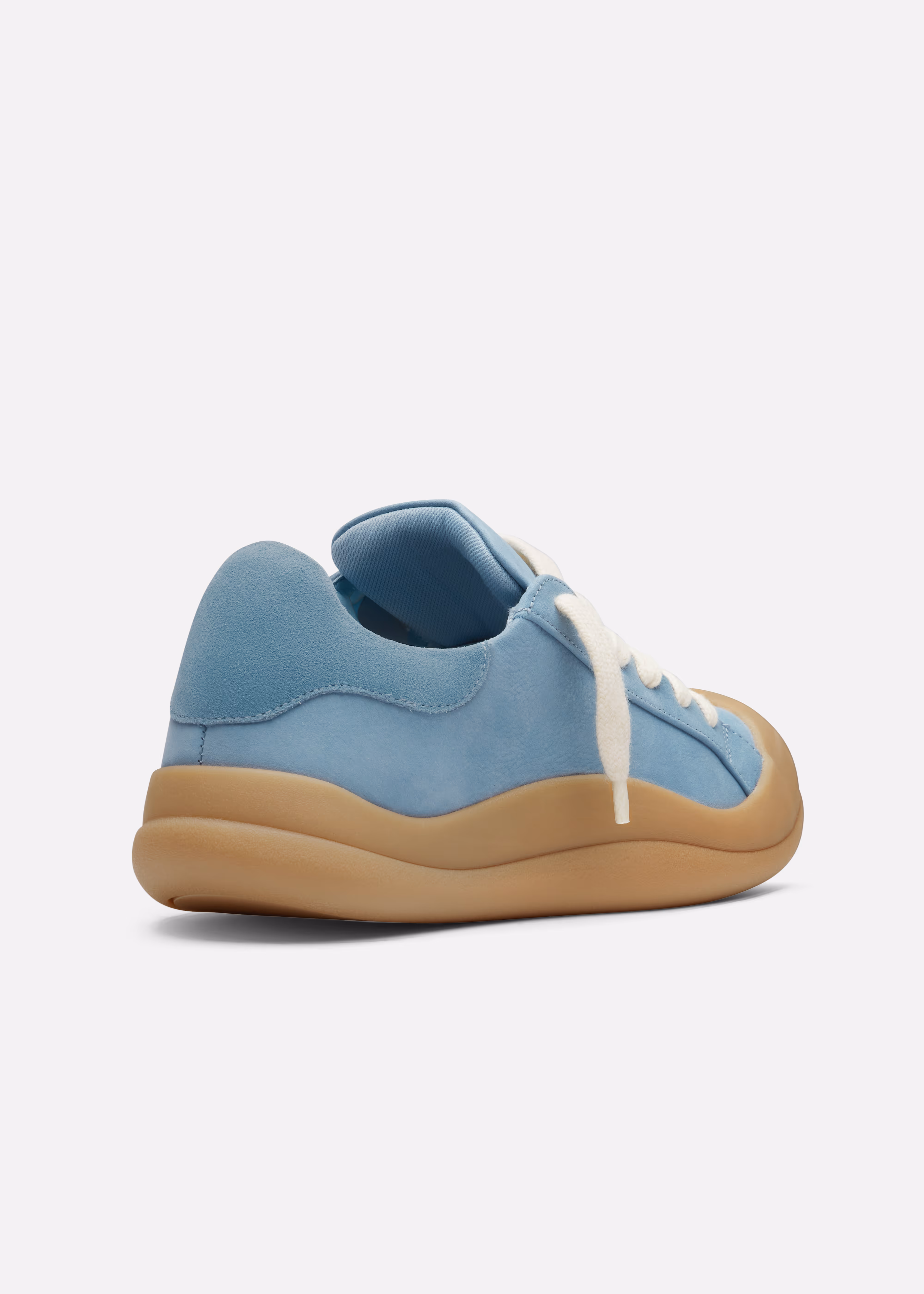 Side view of a light blue Axel Arigato sneaker with white laces and a thick tan sole on a white background.