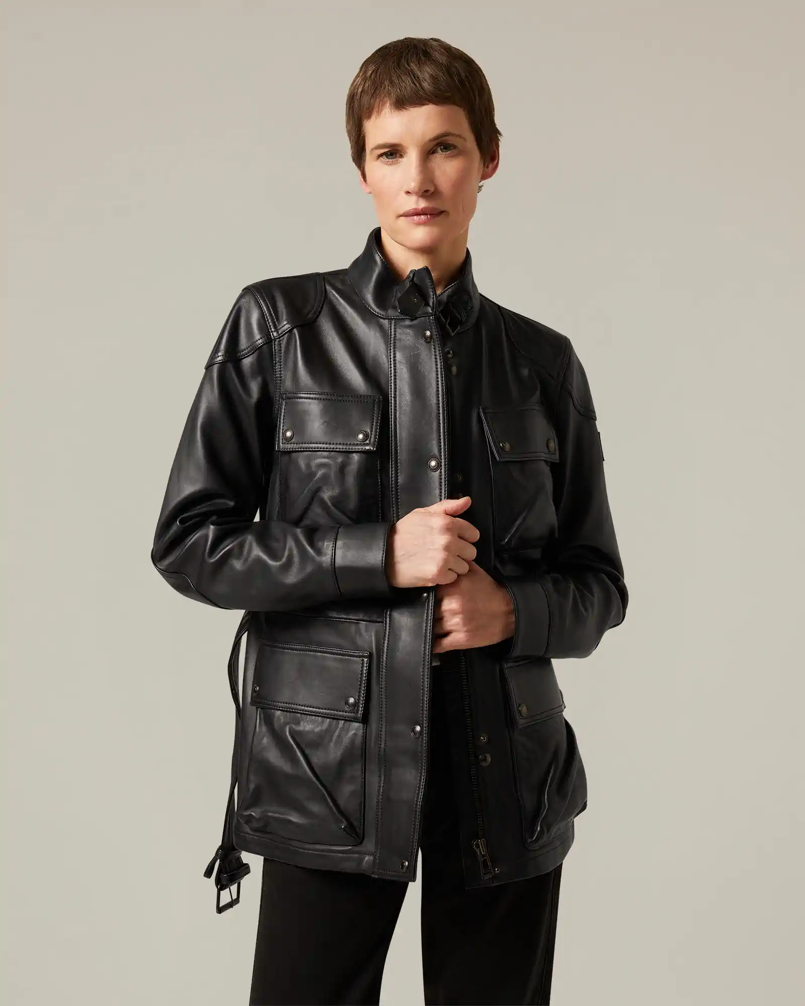 Person wearing a black Belstaff leather jacket with four pocket flaps and a stand collar.