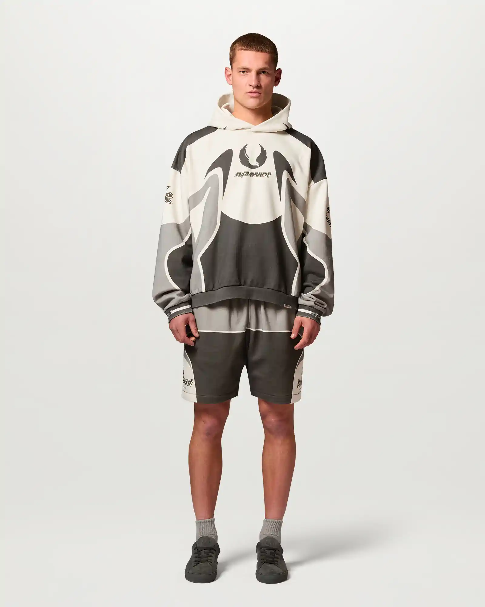 Man wearing a hooded Belstaff sweatshirt and matching shorts with black and gray color patterns.
