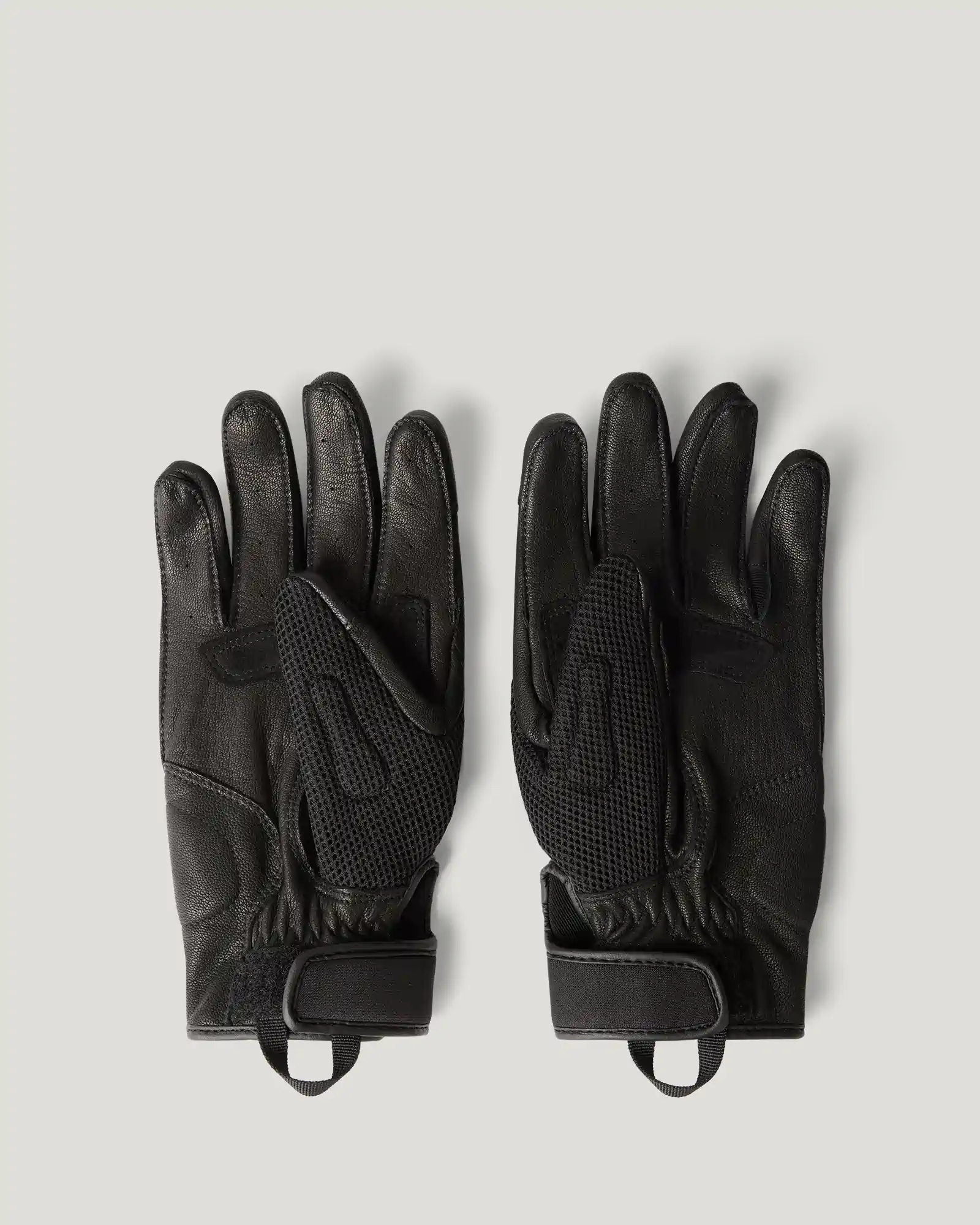 Pair of black Belstaff gloves with mesh and leather details and Velcro wrist straps on a gray background.