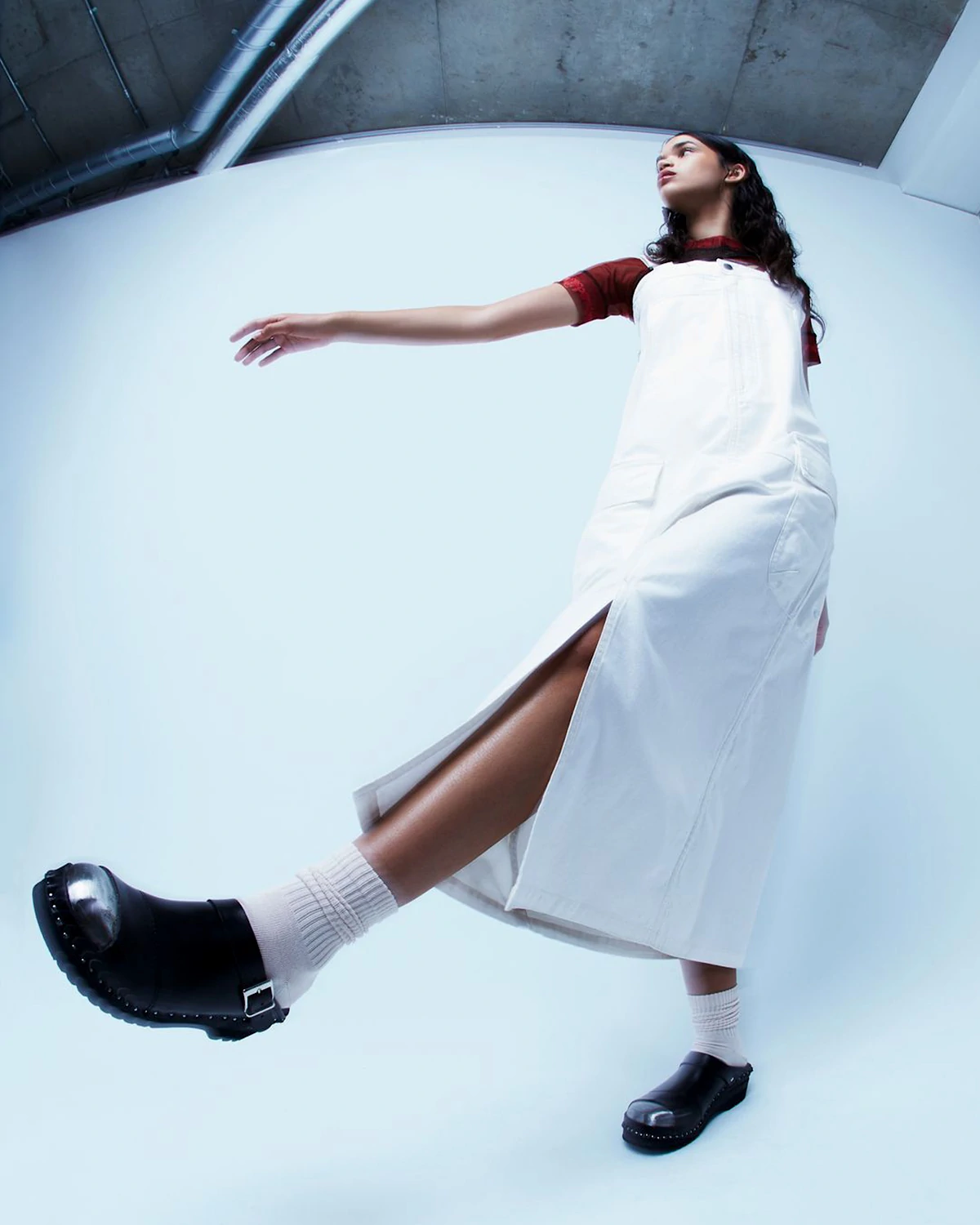 LRP model in a white dress and black clogs with white socks, posing against a light background.