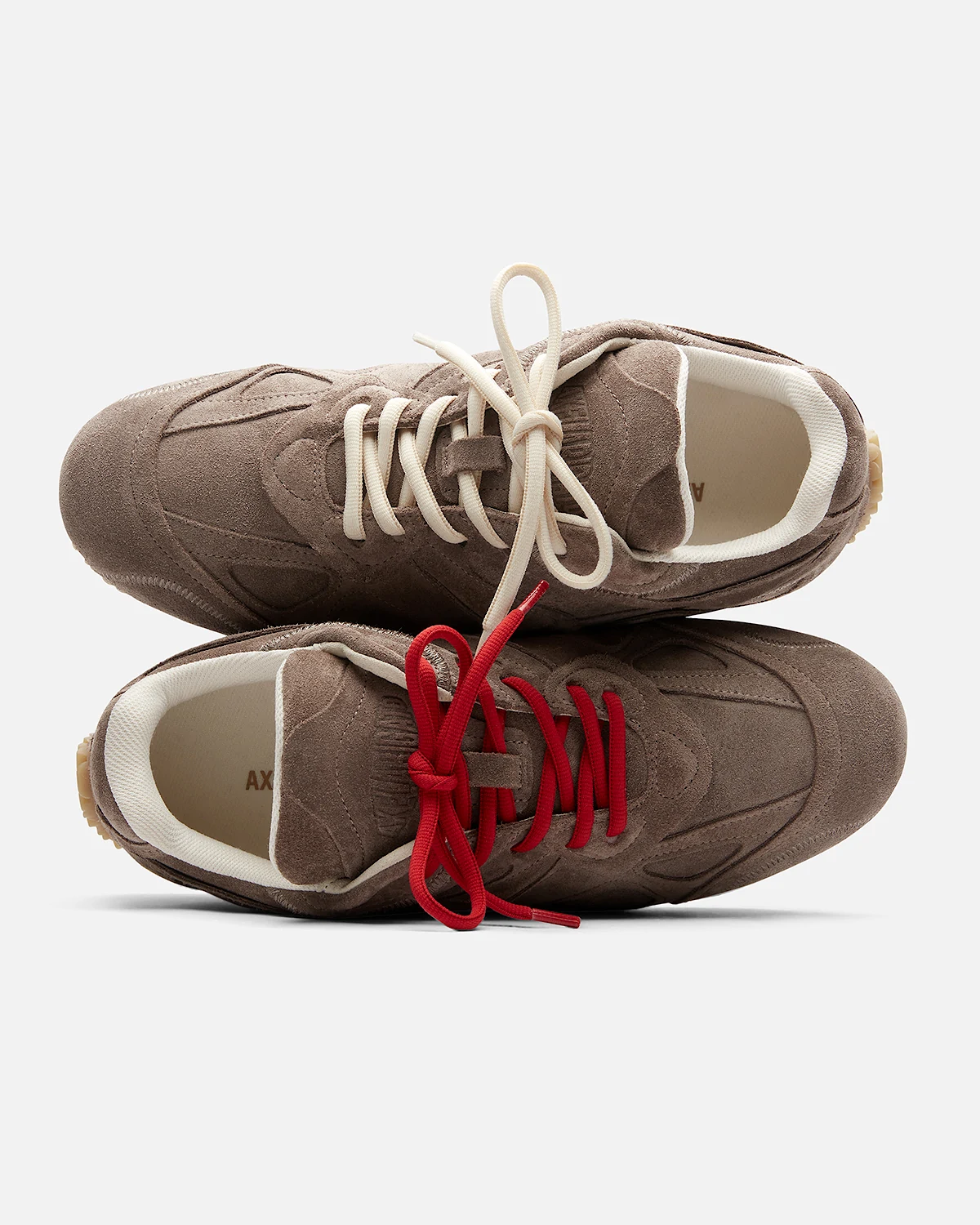 Pair of brown shoes viewed from above with beige and red laces.