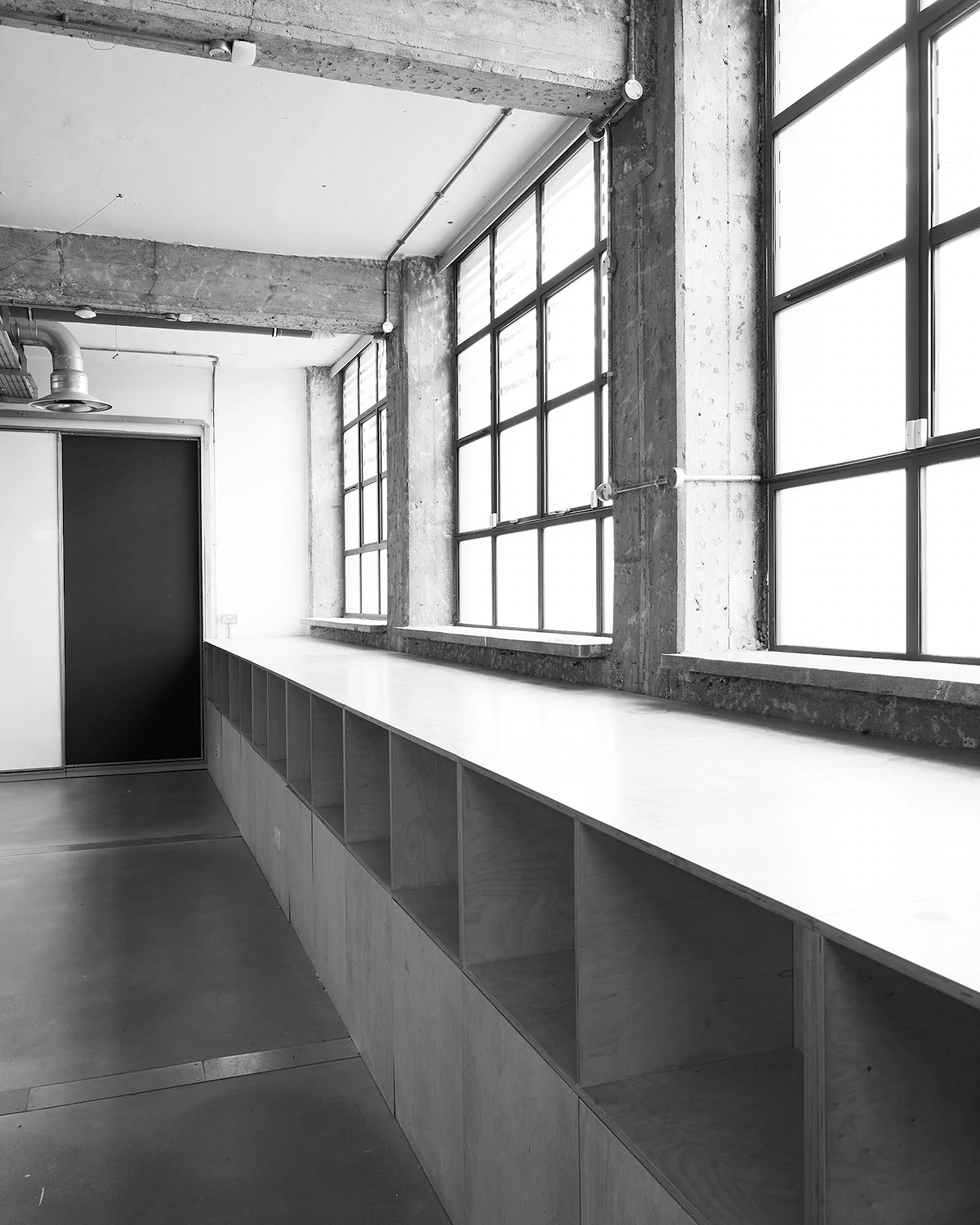 LRP Studio space with large windows and a long wooden counter with cubby shelves.