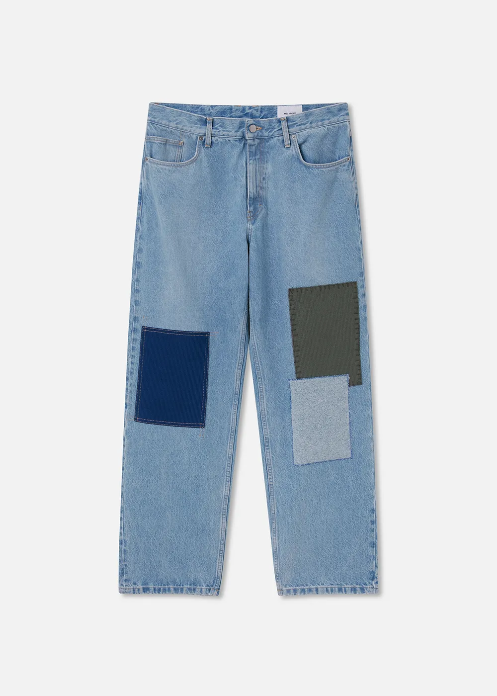 Light blue Axel Arigato jeans with three large stitched patches on the front legs in dark blue, grey, and green.