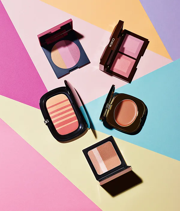 Five open makeup compacts with blush and bronzer shades on a multicolor geometric background.