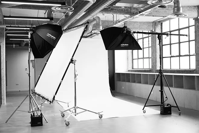 Black and white image of a professional lighting setup at LRP studios, featuring a seamless white backdrop, large softboxes, and a diffusion panel ready for eCommerce photography.