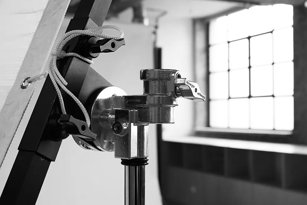 Black and white close-up of a professional grip head and lighting stand at LRP studios, showing the high-end equipment used for eCommerce photography.