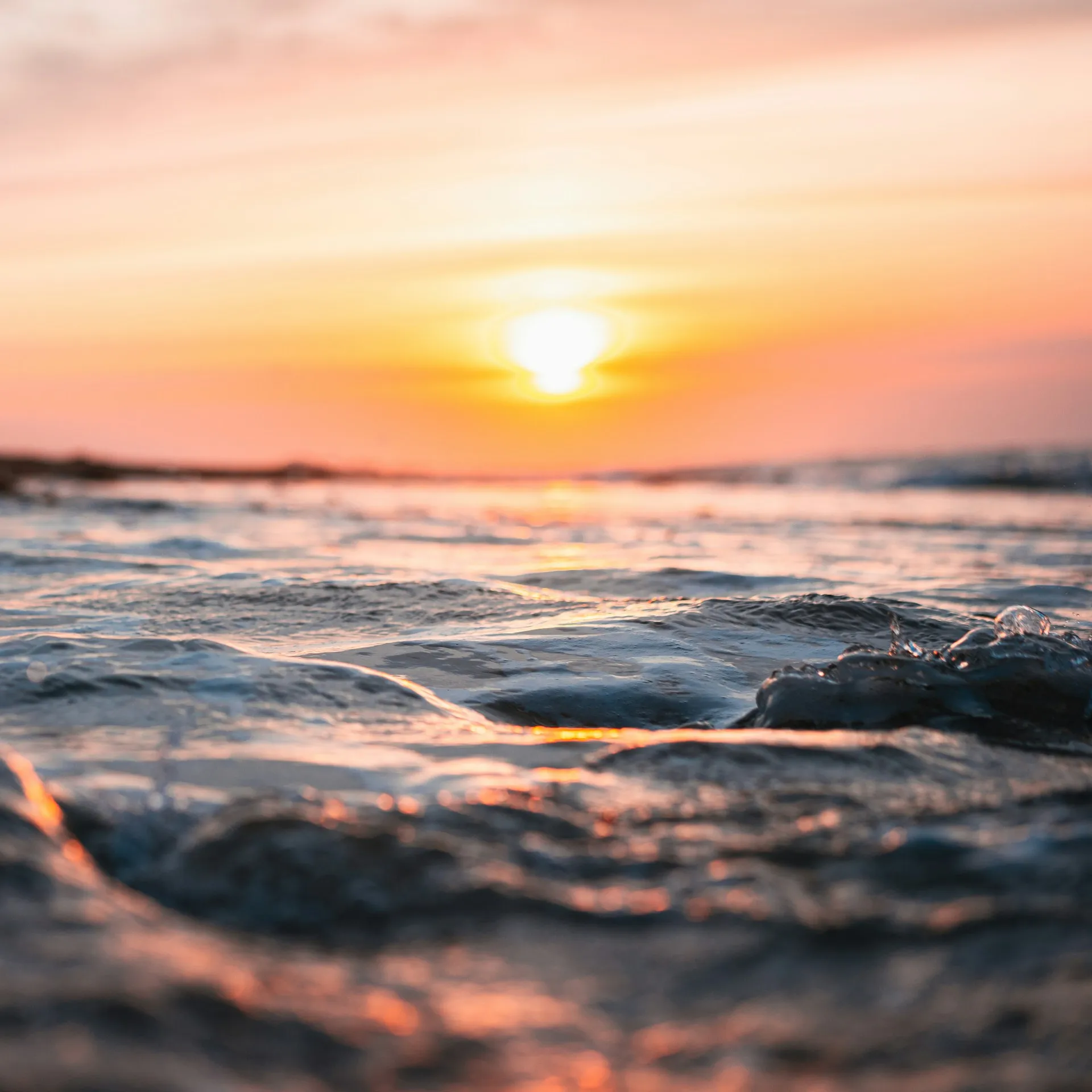 A glowing sunrise over calm water, representing the optimism and fresh start that comes with a solid financial plan.