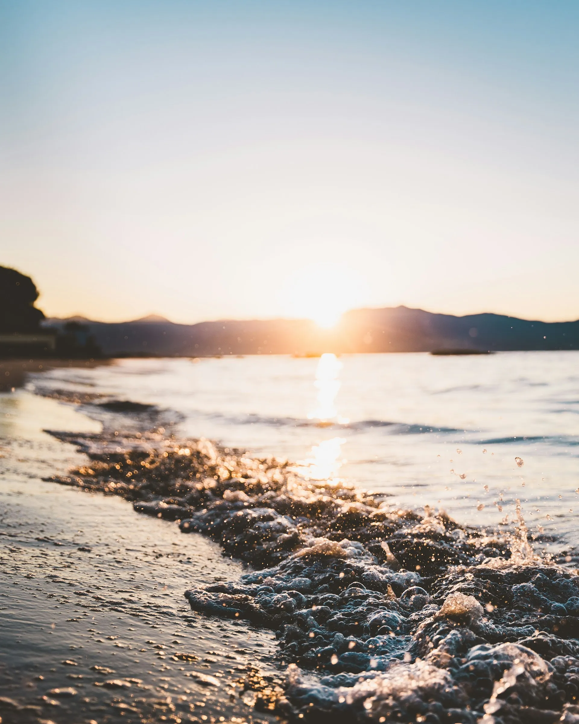 A serene beach shoreline at sunset with warm golden light, evoking the peace and security of a thoughtfully planned financial future.