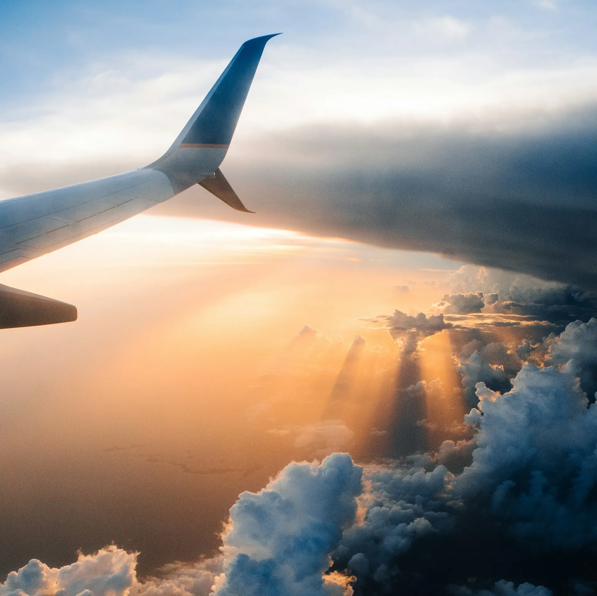 An aerial view of clouds from a plane window at sunrise, representing the freedom and possibility of a well-planned retirement.