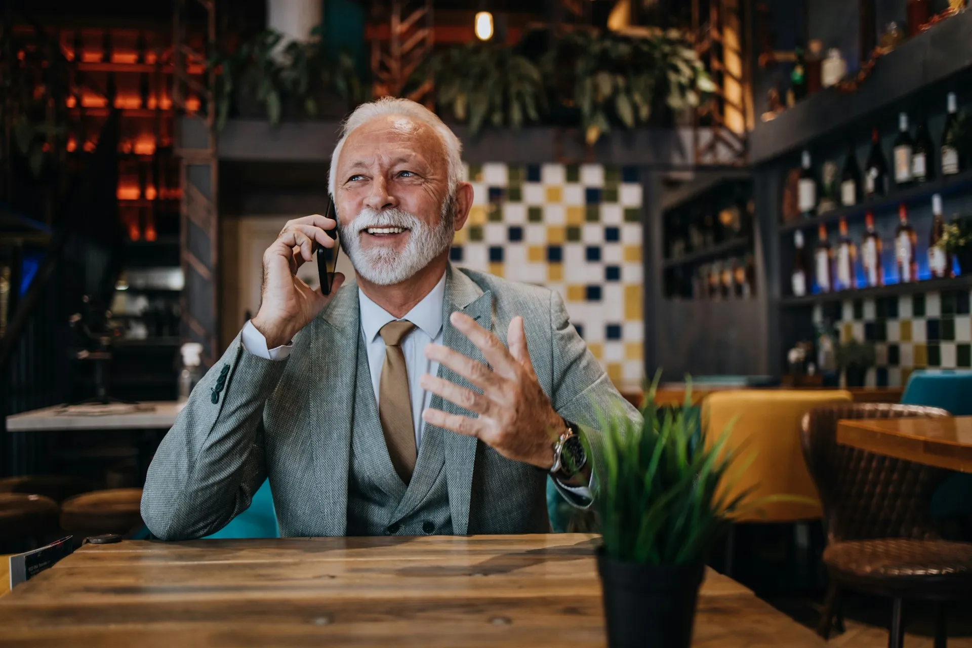 A man working at his desk while on a phone call, representing the busy professionals Sears Group helps manage their financial futures.