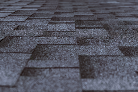 Close-up of dark gray asphalt roof shingles arranged in a staggered pattern.