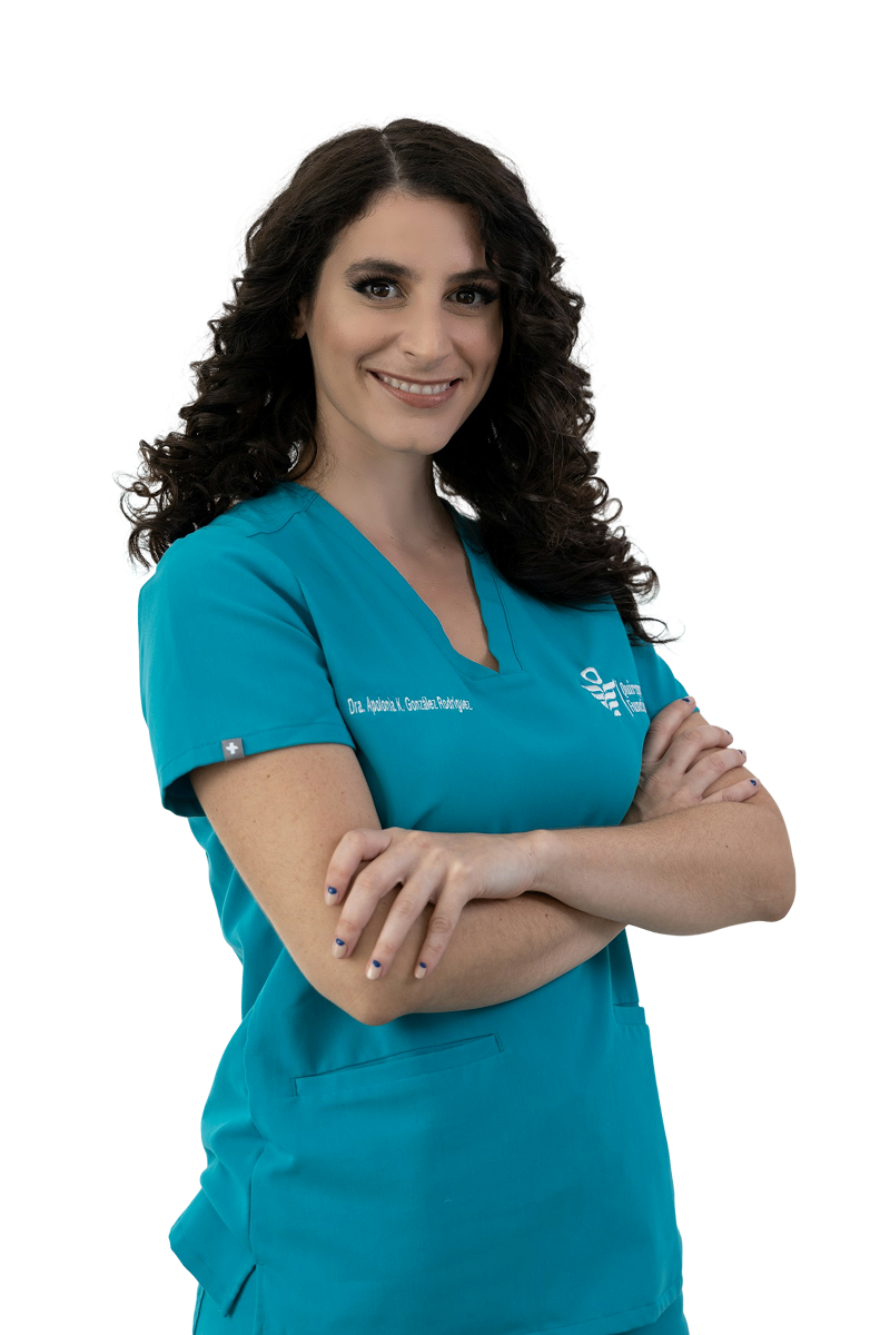 Smiling woman with curly hair in teal medical scrubs, arms crossed.