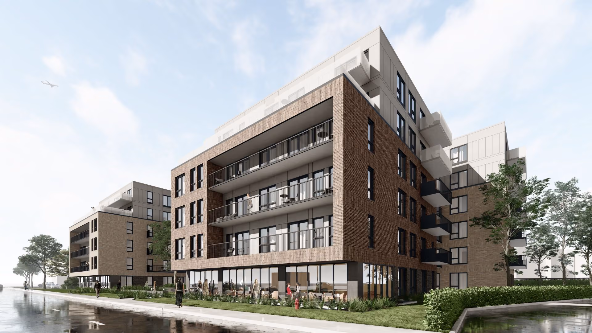 Modern multi-story apartment buildings with balconies, green landscaping, and people walking nearby.