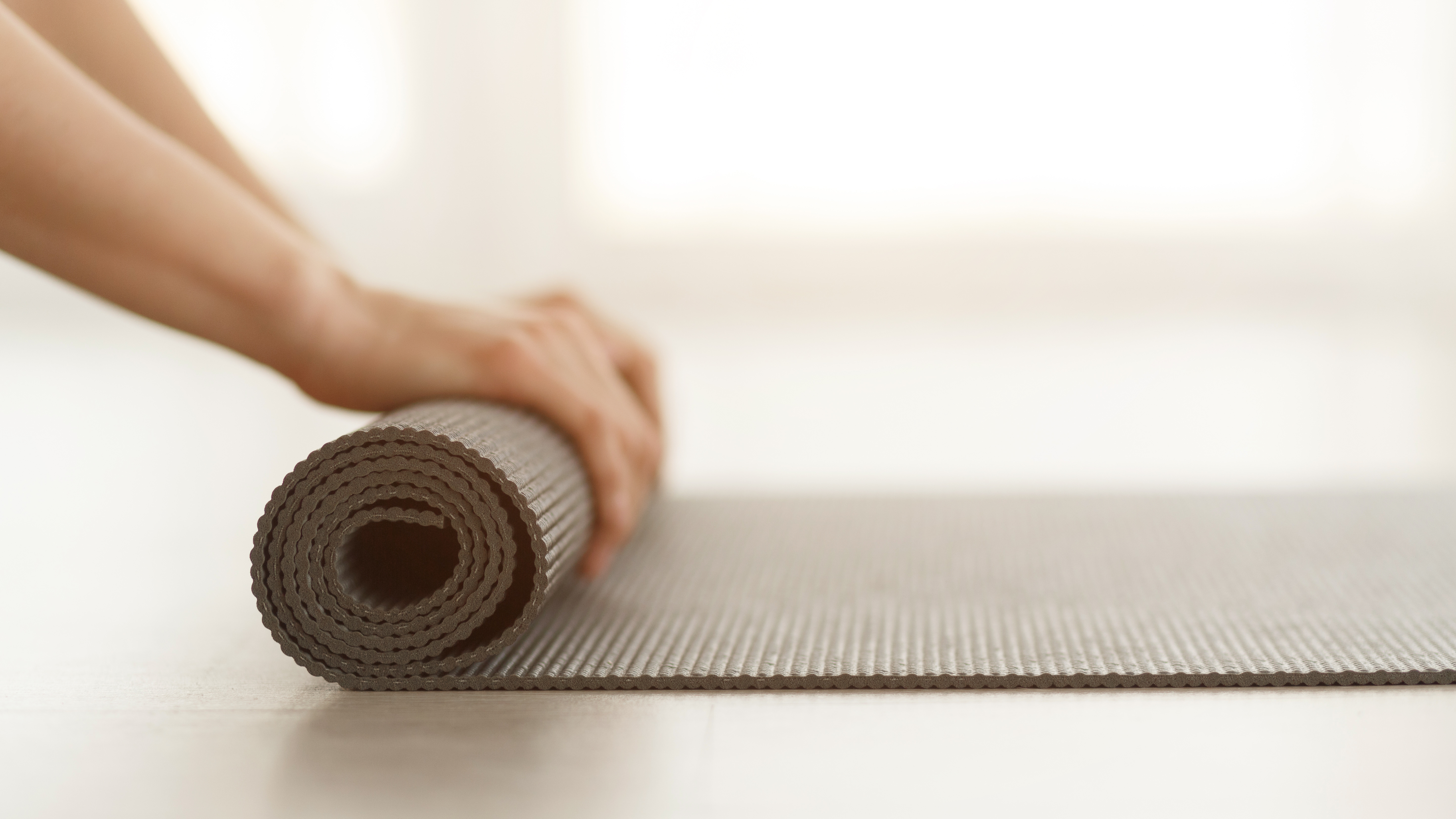 Woman rolling up mat stock image