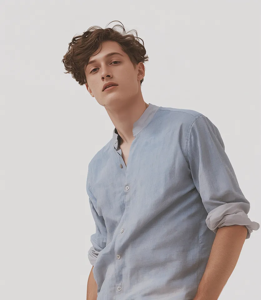 Portrait of a young man in a light blue shirt against a white background