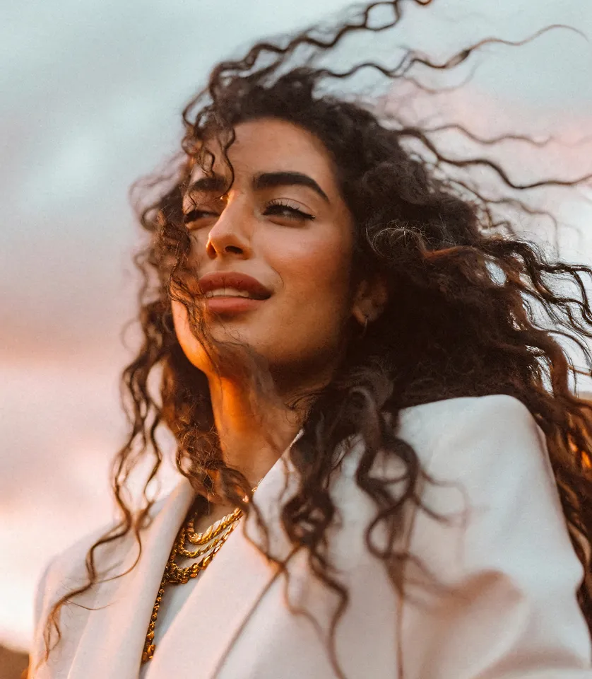 Portrait of a woman with curly hair against a dark background