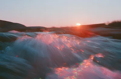 Aerial view of ocean waves at sunset
