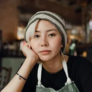 Portrait of a woman in a beanie resting her chin on her hand